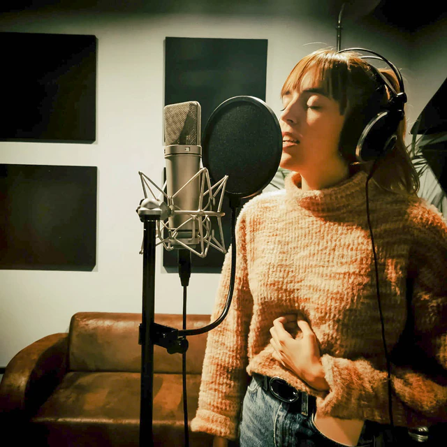 Una cantante interpretando frente al micrófono en MainTrack Studio
