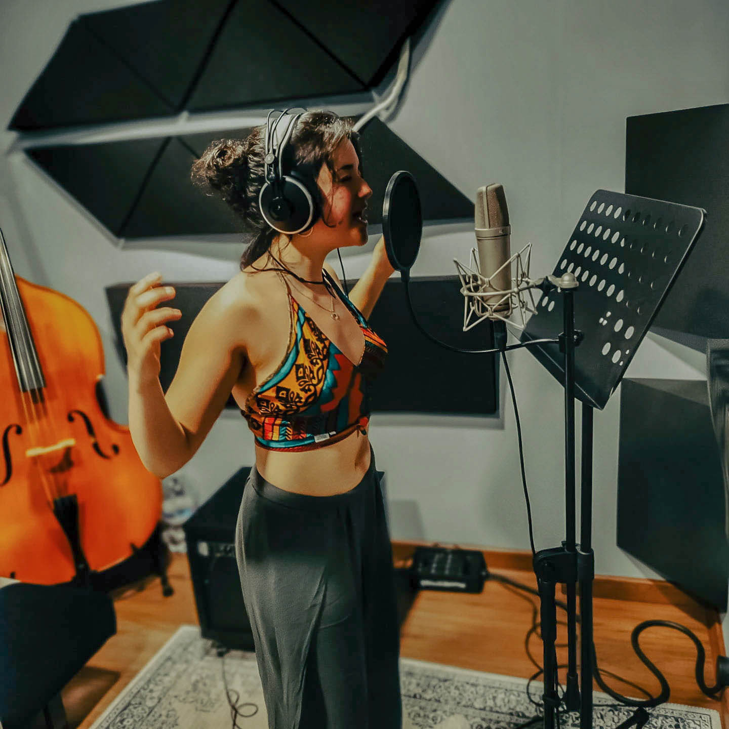 Una cantante grabando una toma vocal con auriculares en MainTrack Studio